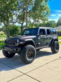 a black jeep parked on top of a driveway