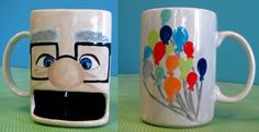 two coffee mugs with balloons painted on them sitting next to each other, one has a man's face