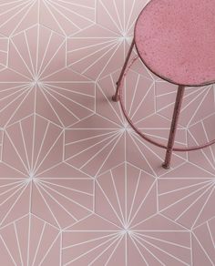 a pink table sitting on top of a floor next to a white and pink wall