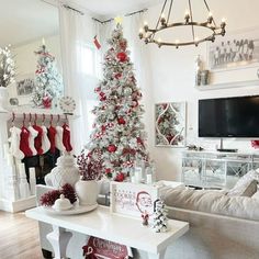 a living room decorated for christmas with white and red decorations