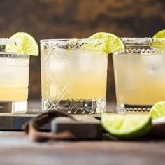 three glasses filled with lemonade and lime slices