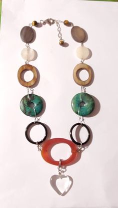 "Attractive natural choker necklace that can worn daily. In great vintage condition. Center of necklace is large round open center Carnelian gemstone Round open circle green turquoise beads. Brown Agate open oval bead. Also frosted  crystal round bead. And brown Agate in oval shape. Three small Tiger Eye beads at the end of necklace. The gemstones are link with sterling silver wire. Measures 10\" around the necklace. Lobster clasp is 9.25 Sterling Silver" Handmade Retro Necklace, Green Bohemian Circular Jewelry, Bohemian Green Circular Jewelry, Green Circle Bohemian Jewelry, Handmade Vintage Round Turquoise Necklace, Retro Round Turquoise Jewelry, Retro Turquoise Jewelry, Vintage Green Round Turquoise Necklace, Vintage Green Turquoise Round Necklace