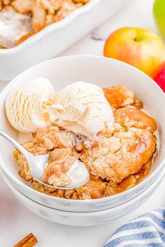 an apple cobbler in a bowl with ice cream and cinnamon sticks next to it