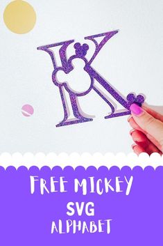 a person is cutting out the letter k with purple glitters and holding a pair of scissors