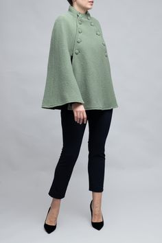 Meet the Margaret Cape: Crafted from 100% virgin wool, this elegant cape combines classic style with modern sophistication. It features a defined collar, a double-breasted front with fabric-covered buttons, and flowing bell sleeves for a dramatic flair. Ideal for transitioning from day to evening, the Margaret Cape offers warmth, comfort, and a polished look that captures timeless elegance. Perfect for anyone seeking a chic, functional wardrobe staple. Elegant Cape, Functional Wardrobe, Cape Designs, Cashmere Cape, Green Sage, Pink October, Wool Cape, Capes For Women, Vest Blazer