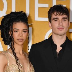 a man and woman standing next to each other on a red carpet at an event