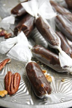 some pecans and nuts are on a silver platter with white paper wrappers