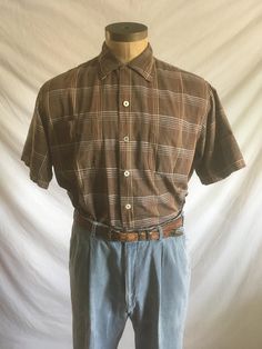 vintage 1950s men's button up shirt 'Imported Fabric' cotton slub fabric selvedge button up front loop collar collar stays (removable) brown w/black thread undertone  w/grays, yellow, browns pin stripes plaid pattern short sleeve straight hem 2 breast pockets good vintage condition, light wear- tiny scrape hole to back shoulder but has lined fabric underneath upper right back black thread nubs-see photos (slub fabric is characterized by light 'irregularities' in fabric threads/weave) labeled siz Unstructured Brown Collared Shirt, Vintage Unstructured Collared Tops, Classic Plaid Short Sleeve Shirt For Summer, Unstructured Collared Vintage Tops, Brown Relaxed Fit Button-up Short Sleeve Shirt, Brown Short Sleeve Shirt With Button Closure For Summer, Classic Brown Short Sleeve Shirt For Summer, Brown Short Sleeve Shirt With Placket, Brown Vintage Relaxed Fit Top