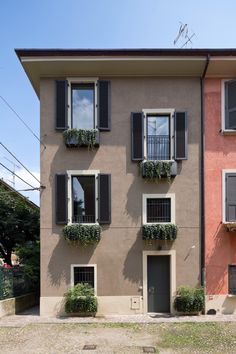 an apartment building with many windows and plants on the balconies