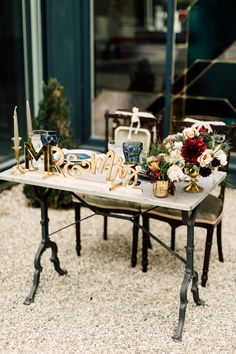 a table that has some flowers on it and candles in front of it with the word mr and mrs spelled out