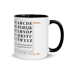 a black and white coffee mug with the alphabet in it's center, on a white background