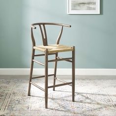 a wooden chair sitting on top of a rug in front of a blue painted wall