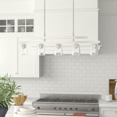 a kitchen with white cabinets and an island in front of the stove top is shown