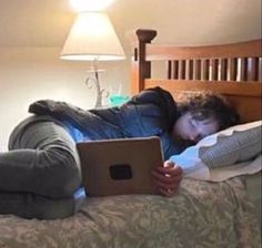 a person laying on a bed with a laptop