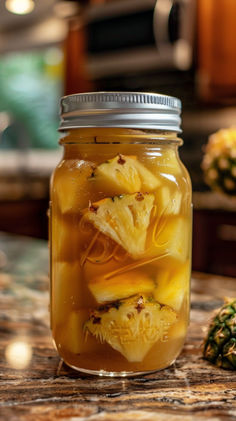 a jar filled with sliced pineapples sitting on top of a counter