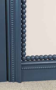 a close up of a blue frame with beads on the edges and bottom part of it