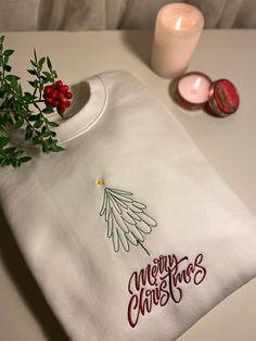 Step into the festive spirit with our high-quality Christmas-themed embroidered sweatshirt! This exquisite design features a beautifully detailed Christmas tree adorned with delicate embroidery, accompanied by the heartwarming message 'Merry Christmas' below. Our sweatshirt is not just a piece of clothing; it's a celebration of the season, making it a perfect gift for your loved ones. Crafted with precision and care, this sweatshirt strikes the perfect balance between elegance and simplicity. The intricate embroidery adds a touch of sophistication, ensuring a timeless and durable piece that will last throughout the holiday seasons. Ideal for gatherings, parties, or as a unique christmas gift, our Christmas sweatshirt is a versatile addition to your festive wardrobe. Embrace the joy of givi Embroidered Christmas Holiday Sweatshirt, Christmas Holiday Embroidered Sweatshirt, Christmas Embroidered Sweatshirt, Christmas Embroidery Sweatshirts, Embroidered Christmas Sweatshirt, Christmas Sweatshirt Ideas, Christmas T Shirt Design, Embroidery Christmas, Delicate Embroidery