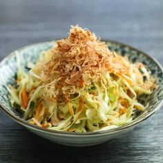 a bowl filled with coleslaw on top of a wooden table