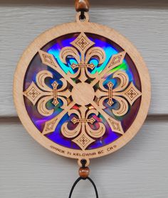 a wooden wind chime hanging from the side of a door with an intricate design on it