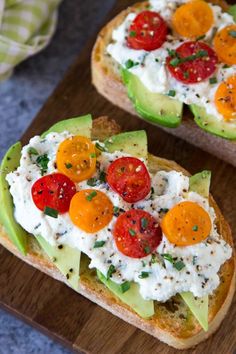 two slices of bread with tomatoes, avocado and sour cream on them