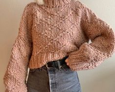 a woman with blonde hair wearing a sweater and jeans