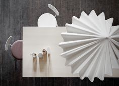 an overhead view of a table with several objects on it, including a paper fan