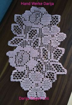 a white doily on top of a wooden floor with the words hand weave daria written