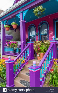 purple and blue house with flower pots on the front porch