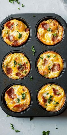 mini pizzas in a muffin tin with cheese and bacon on top, ready to be eaten