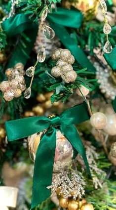 a christmas tree with ornaments hanging from it's sides and green ribbon on the top