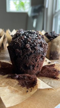 a chocolate muffin sitting on top of brown paper