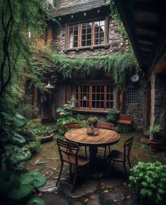 an outdoor table and chairs in front of a stone building with ivy growing on it