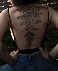 the back of a woman's body with tattoos on her upper and lower back