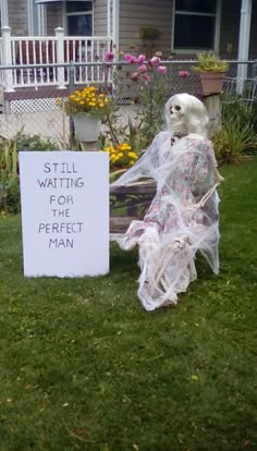 a ghost sitting in the grass next to a sign that says still waiting for the perfect man