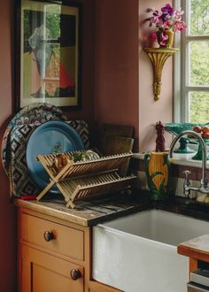 a kitchen sink sitting next to a window filled with dishes