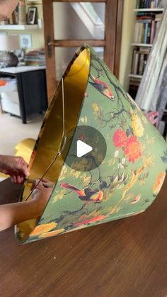 a young boy is working on a lamp shade that has flowers and birds on it