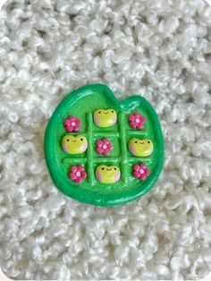 a close up of a plastic toy with flowers on it's center and four little pigs in the middle