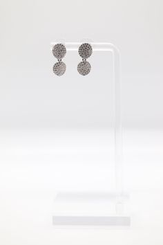 These earrings are made of silver and have two clusters of cubic zirconia stones. The clusters are arranged in a unique and eye-catching design that will turn heads wherever you go. The earrings are perfect for any occasion, from a casual day out to a special evening on the town.