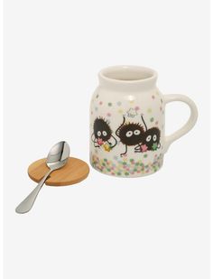 a mug with two hedges on it next to a small spoon and wooden coaster