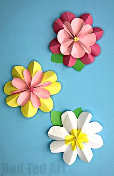 three paper flowers on a blue background