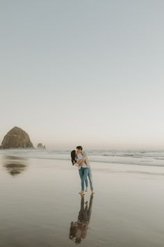 an engaged couple kissing on the beach in cannon rock state park, oregon during their engagement session