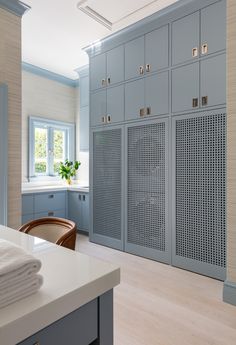 a kitchen with blue cabinets and white counter tops