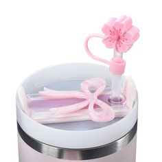 a pink flower and scissors in a container