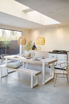 a kitchen with a table, chairs and an oven in the back ground next to a window