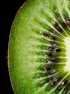 a kiwi cut in half on a black background