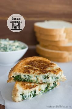 a grilled cheese sandwich with spinach and arugula spread on the side