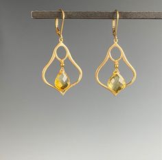 "Introducing our stunning Citrine earrings - the perfect accessory to add a touch of elegance to any outfit. Made with exquisite craftsmanship and attention to detail, these earrings showcase the beauty of the golden yellow Citrine stone. Crafted with high-quality materials, these earrings are designed to last, and their timeless style ensures they will never go out of fashion. The Citrine dangles within a Moroccan inspired shape of brushed Vermeil gold. The sparkling Citrine stone is set in a d Elegant Faceted Dangle Teardrop Earrings, Elegant Faceted Teardrop Dangle Earrings, Elegant Gold Teardrop Earrings With Gemstone, Elegant Gemstone Teardrop Chandelier Earrings, Modern Gemstone Earrings For Weddings, Elegant Citrine Jewelry With Gemstone Accents, Elegant Teardrop Crystal Gemstone Earrings, Elegant Citrine Jewelry In Amber, Elegant Gold Faceted Crystal Earrings