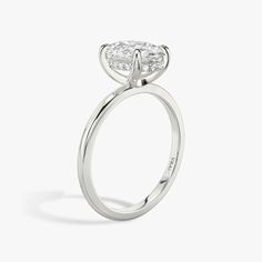 a white gold engagement ring with a pear shaped diamond on the top and side stones