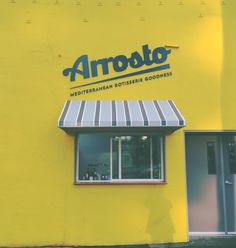 a yellow building with an awning on the front and side of it that says arroboto