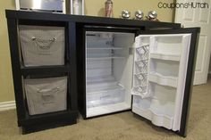 an open refrigerator sitting on top of a carpeted floor